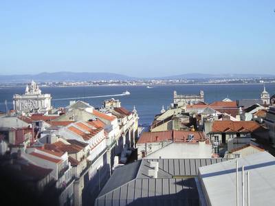 Pohled přes střechy na řeku Tejo i protější břeh, vzdálený odsud přes 2 km