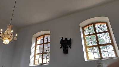 Z rovného stropu v chrámové lodi visí křišťálový lustr