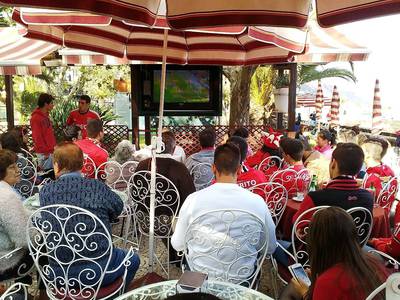 25. Příznivci fotbalu sledují venku na promenádě televizní přenos