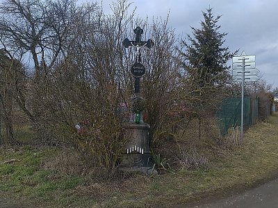 Křížek u cesty. Za povšimnutí stojí svícen dole umístěný.