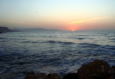 Kréta. Kotouč slunce mizí za obzorem a moře mění barvu.